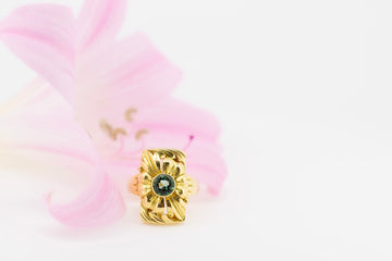 Floral designed 18ct gold ring with a green elbaite stone.